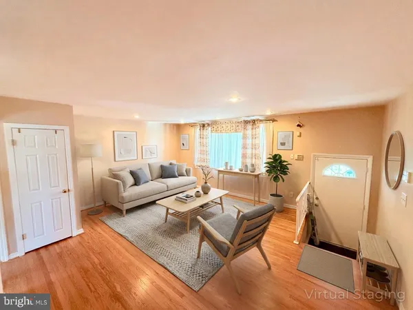 a living room with furniture a wooden floor and next to a window