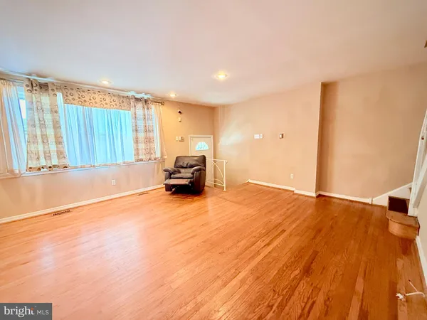 a view of a livingroom with a car parked on the wooden floor