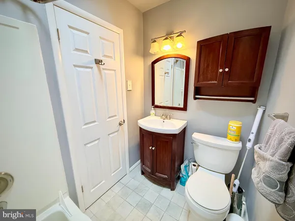 a bathroom with a toilet mirror vanity and sink