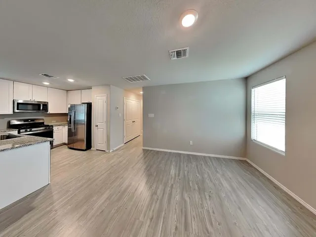 a view of kitchen with wooden floor and electronic appliances