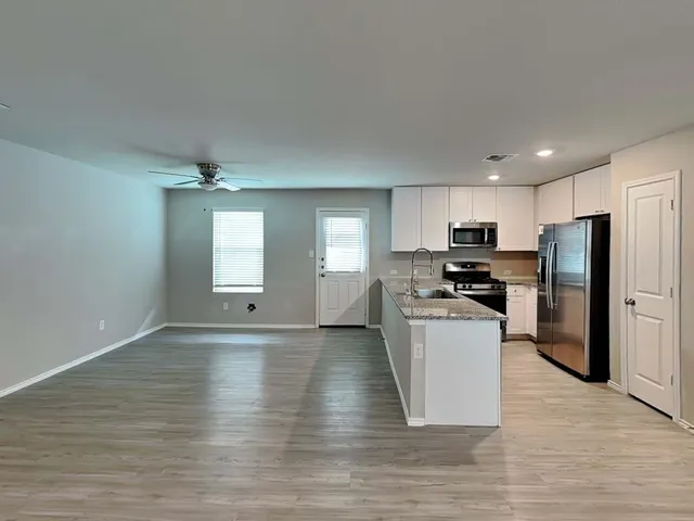 a kitchen with stainless steel appliances a refrigerator and a stove top oven