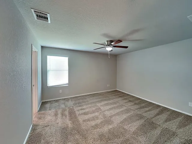 an empty room with a chandelier fan