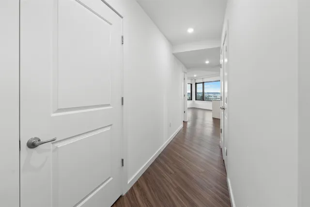 a view of a hallway with wooden floor and staircase