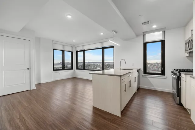 a large white kitchen with wooden floors and white walls