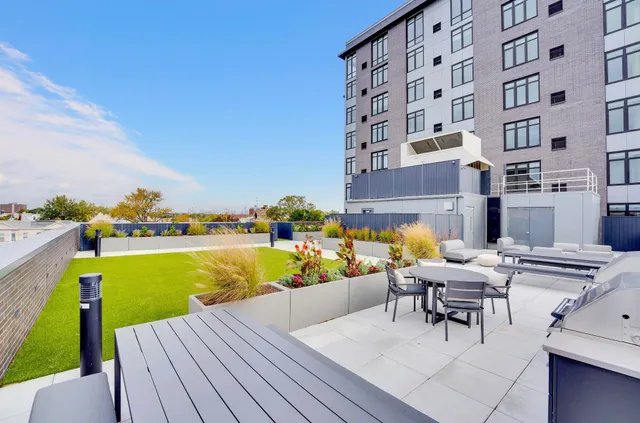 a swimming pool with outdoor seating and a yard