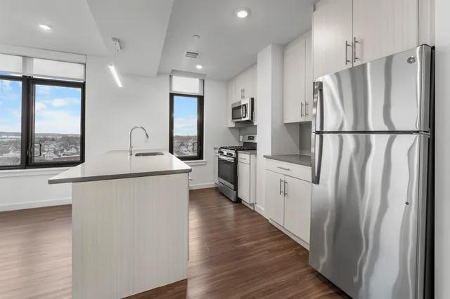 a kitchen with white cabinets and white stainless steel appliances