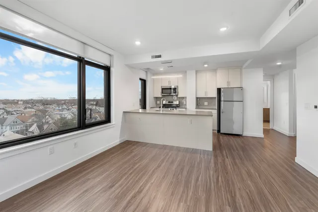 a large kitchen with stainless steel appliances granite countertop a large window a oven and a large window