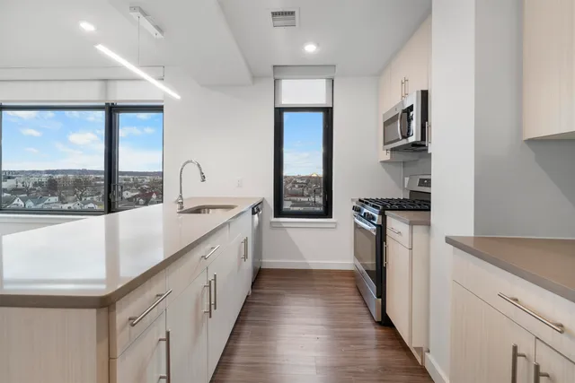 a kitchen with counter top space and wooden floor