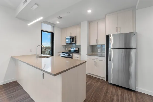 a kitchen with a refrigerator a sink and a stove top oven
