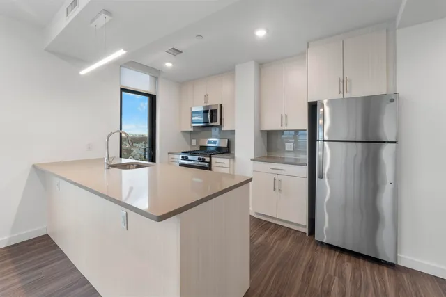 a kitchen with a refrigerator a sink and a stove top oven