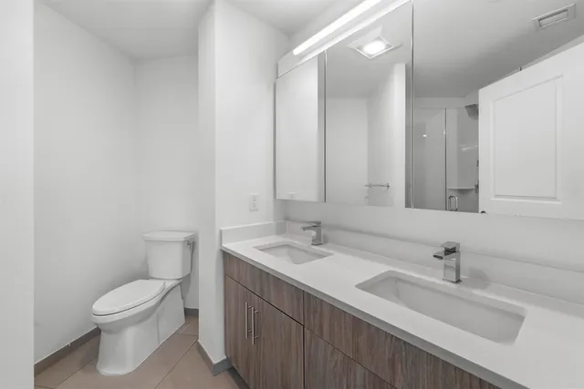 a bathroom with a sink a toilet and a mirror