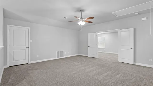 an empty room with a ceiling fan and a window