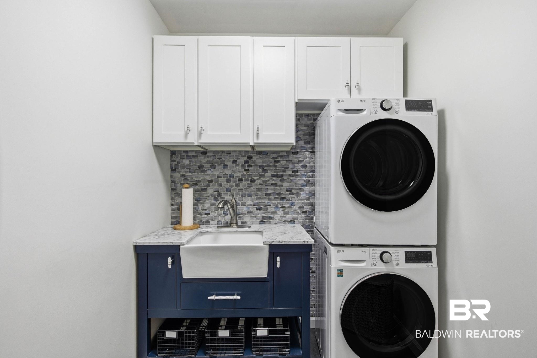 31515 Rhett Drive Spanish Fort, AL 36527 - Photo 57 of 100 The upstairs laundry room has a sliding barn door, Cabinets for storage, a sink, custom backsplash and stack washer dryer.