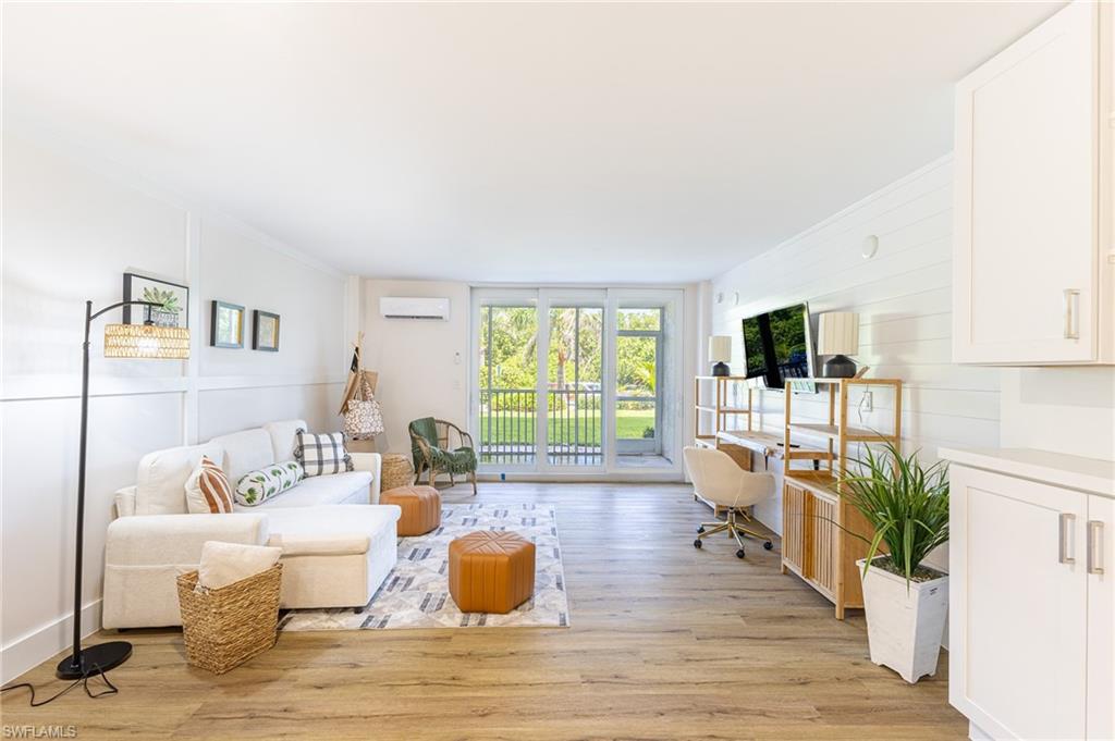 a living room with furniture a flat screen tv and a large window