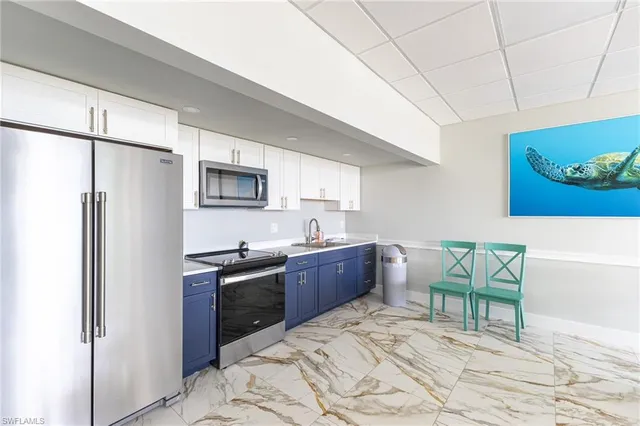 a kitchen with stainless steel appliances granite countertop a refrigerator sink and stove