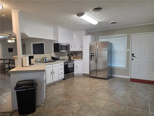 a large kitchen with a refrigerator a stove top oven a sink and dishwasher