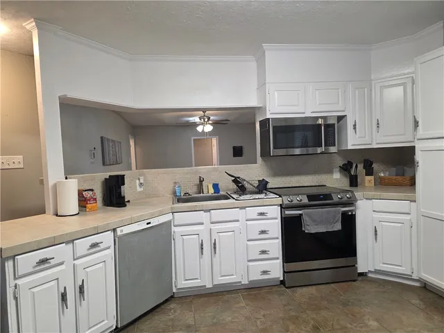 a kitchen with cabinets stainless steel appliances and a sink