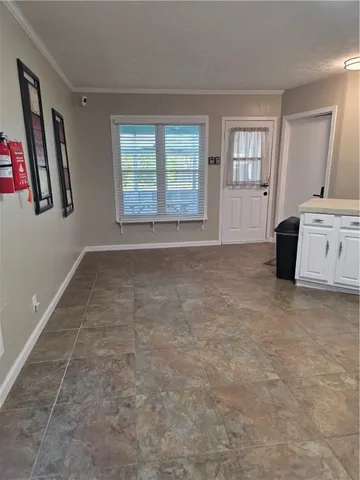 an empty room with windows and cabinet