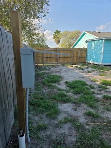 a view of a house with a backyard and a tree