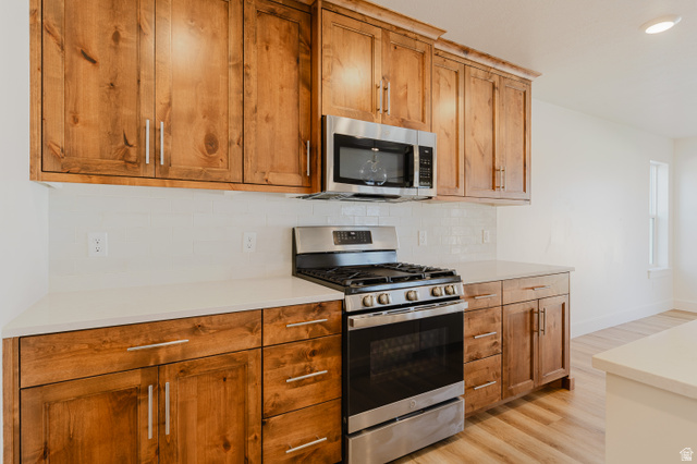 433 North 600 West Smithfield, UT 84335 - Photo 16 of 40 Kitchen featuring wood cabinetry, stainless steel appliances, white subway tile backsplash, and light-toned countertops