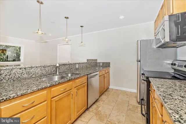 a bathroom with a granite countertop sink and a large mirror
