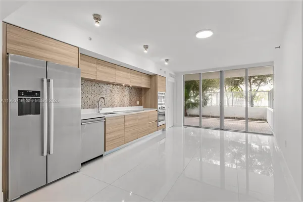 a kitchen with a refrigerator and white cabinets