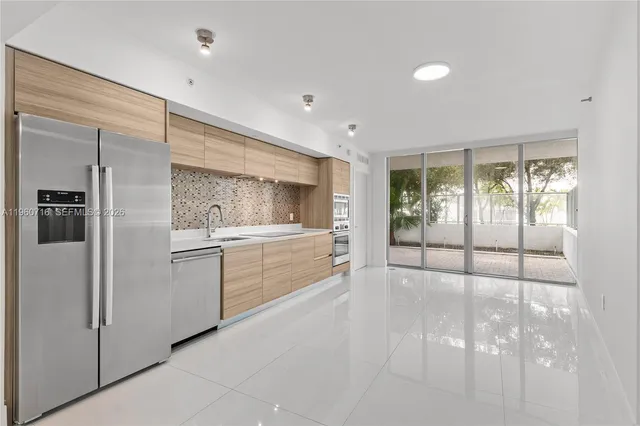 a kitchen with a refrigerator and white cabinets