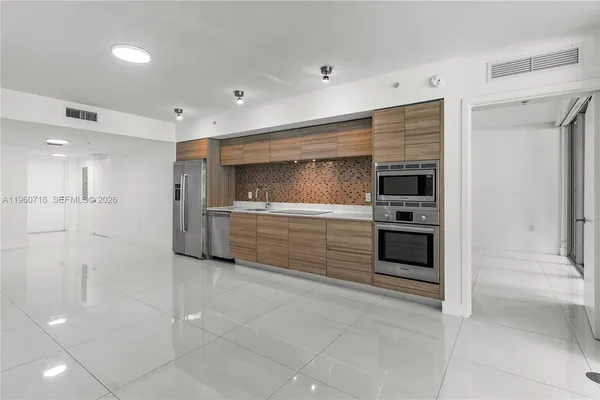 a kitchen with stainless steel appliances kitchen island granite countertop a stove and a sink