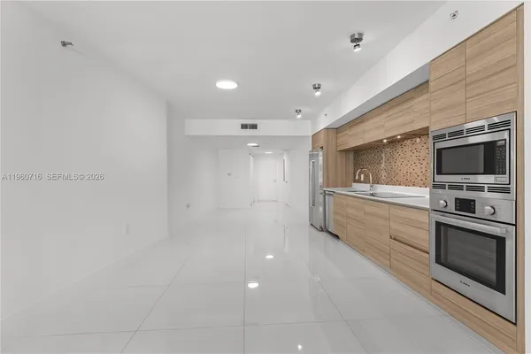 a kitchen with stainless steel appliances a refrigerator and a stove top oven