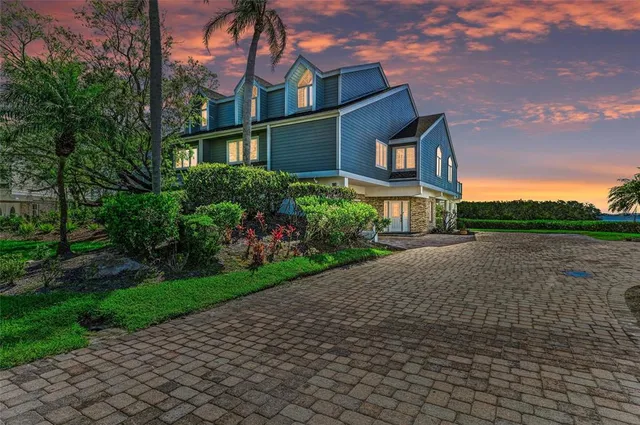 an aerial view of a house with a yard and lake view