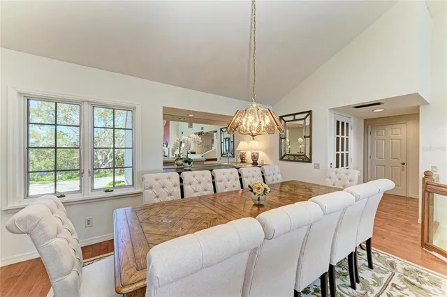 a bedroom with a large bed a chandelier and dresser