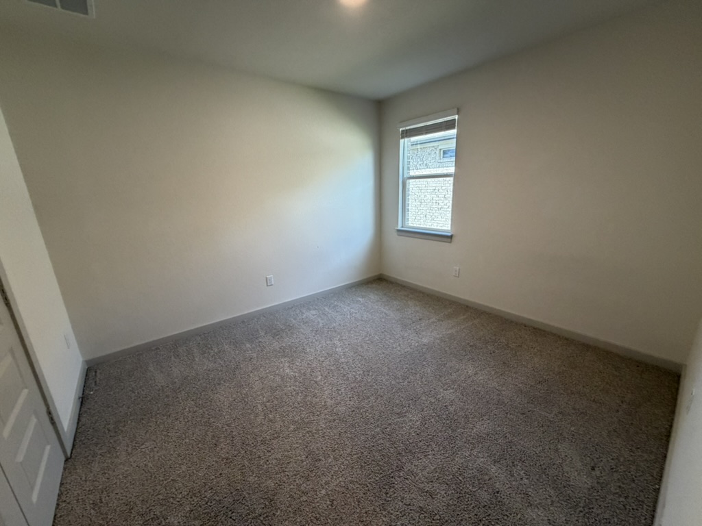 10708 Gonzales Ranger Pass Austin, TX 78754 - Photo 6 of 40 A spacious, naturally illuminated room featuring plush carpet and a well-placed window.