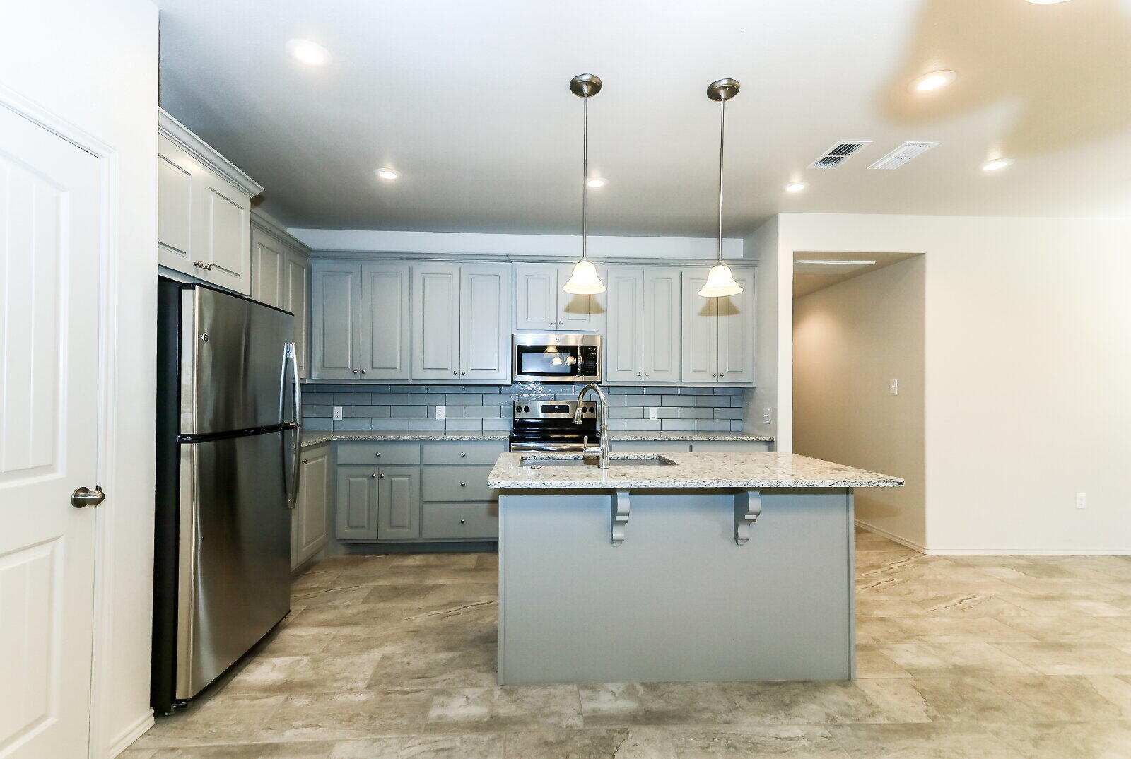 6905 67th Street, Unit B Lubbock, TX 79424 - Photo 14 of 37 a kitchen with a refrigerator sink and cabinets
