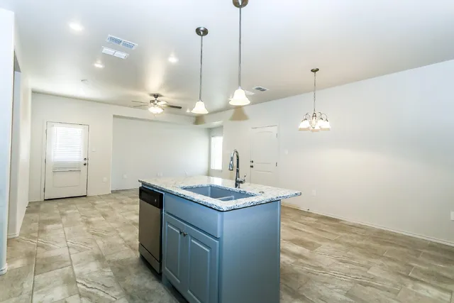 a kitchen with a sink a counter space and a chandelier