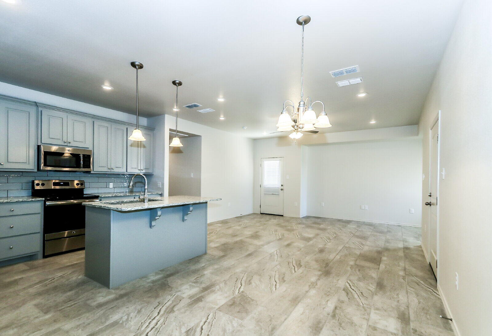 6905 67th Street, Unit B Lubbock, TX 79424 - Photo 20 of 37 a view of a kitchen with granite countertop stainless steel appliances and a chandelier