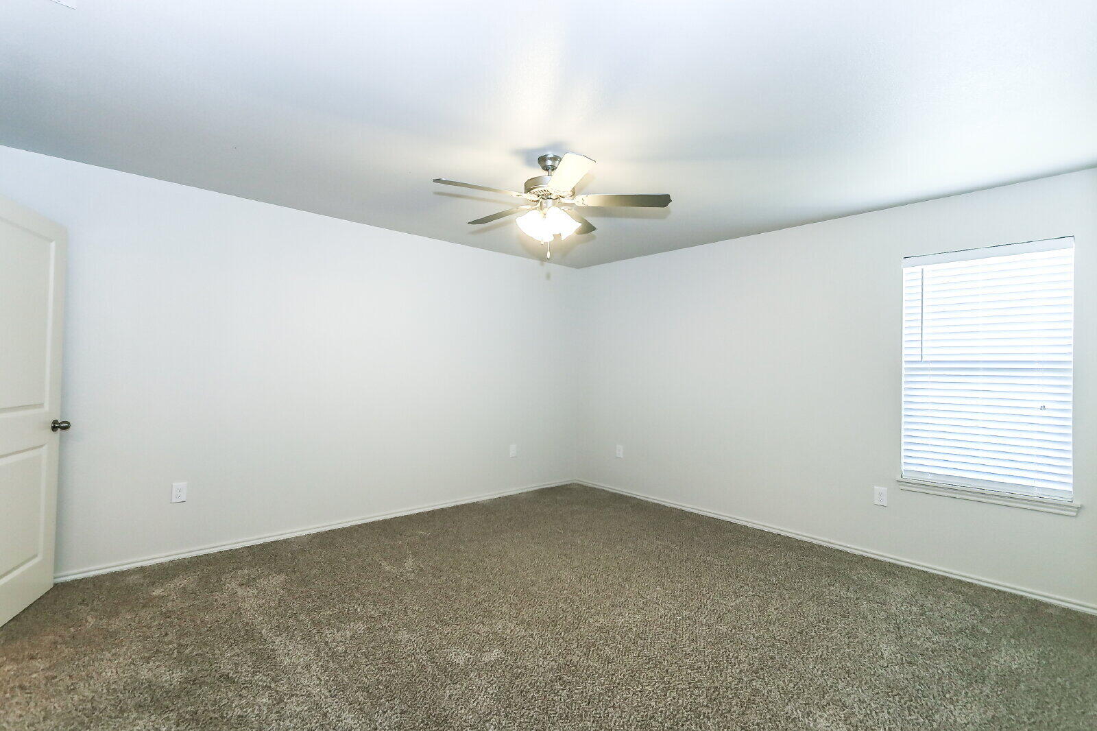 6905 67th Street, Unit B Lubbock, TX 79424 - Photo 21 of 37 an empty room with windows and chandelier fan