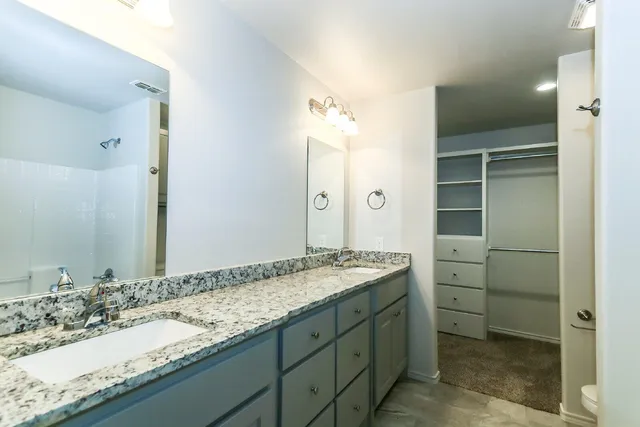 a bathroom with a granite countertop sink and a mirror