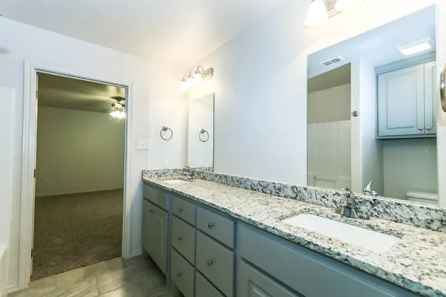 a bathroom with a granite countertop sink and a mirror