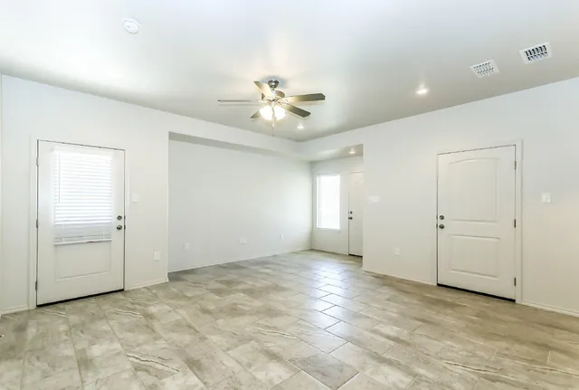 an empty room with closet and a ceiling fan