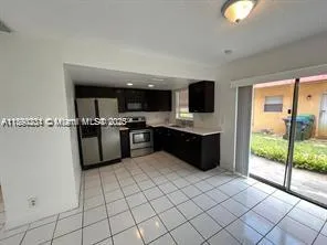 a kitchen with stainless steel appliances a sink a stove a microwave a refrigerator and cabinets