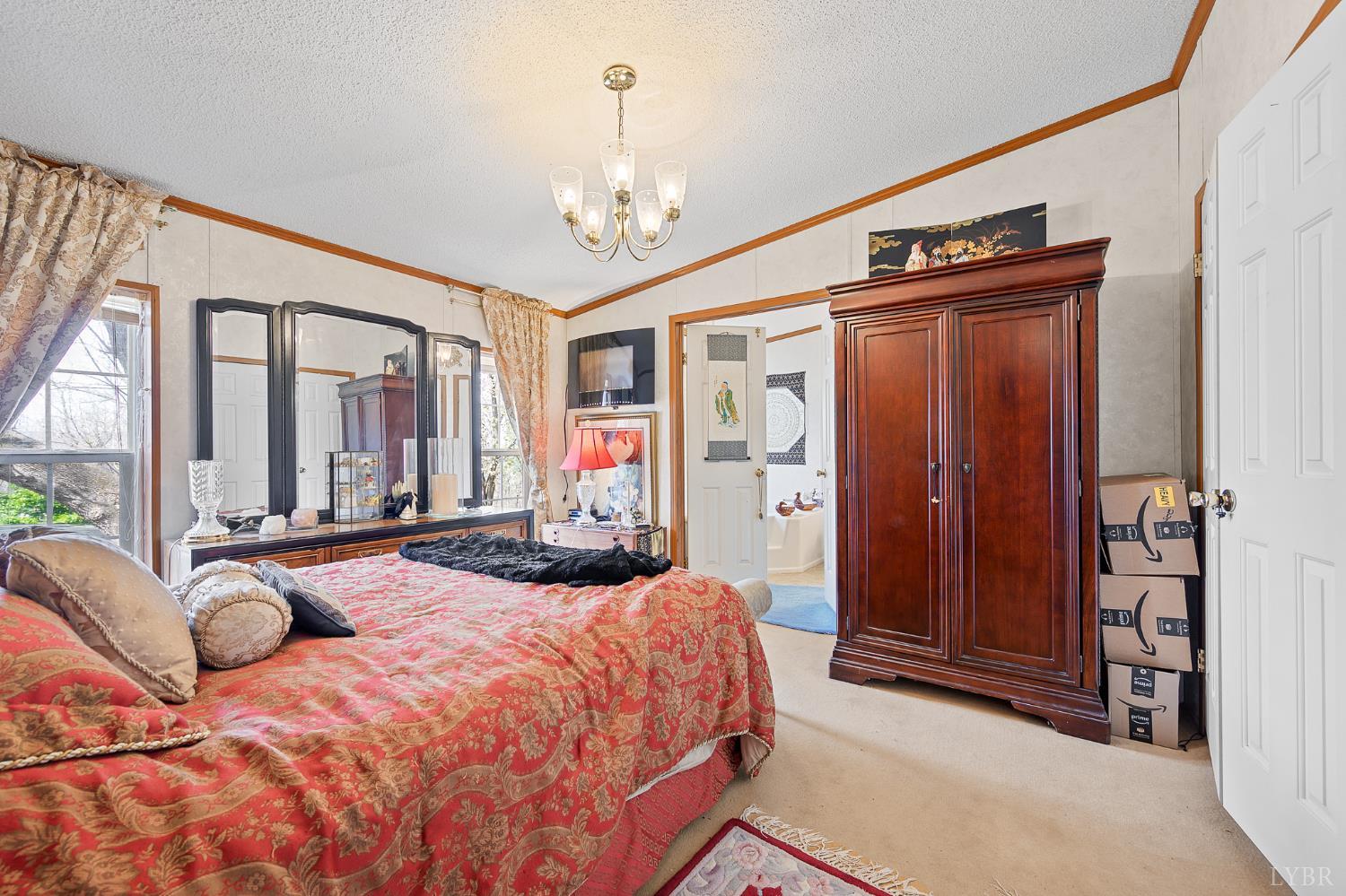 4400 Murray Hollow Road Thaxton, VA 24174 - Photo 16 of 56 a bedroom with a large bed and a chandelier