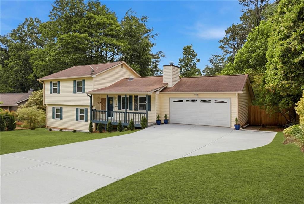 338 Arbour Way Suwanee, GA 30024 - Photo 2 of 32 a front view of a house with a garden and trees