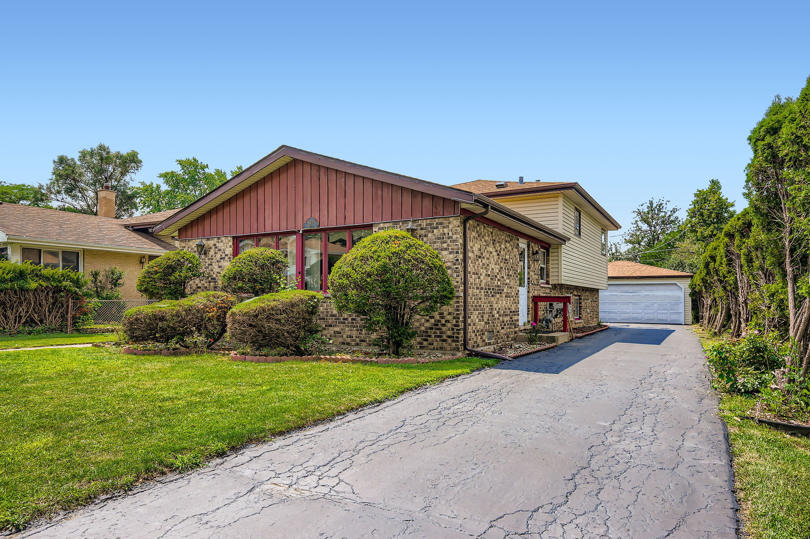a front view of a house with yard and green space