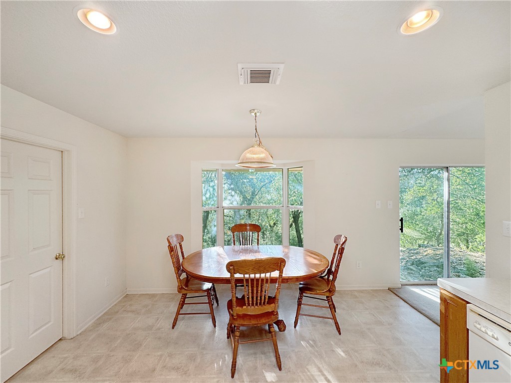 4575 Tanglewood Trail Spring Branch, TX 78070 - Photo 14 of 48 a dining room with furniture a chandelier and wooden floor