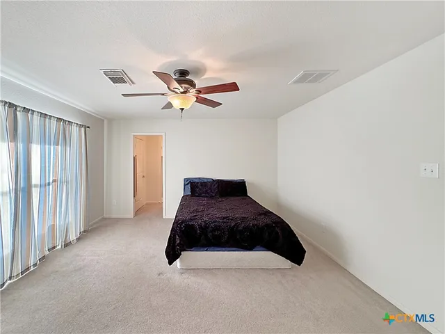 a bedroom with a large bed and a large window