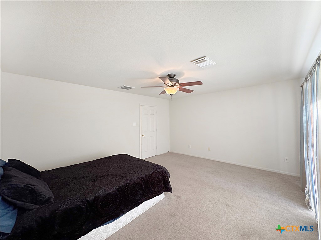 4575 Tanglewood Trail Spring Branch, TX 78070 - Photo 21 of 48 a bedroom with a bed and a ceiling fan