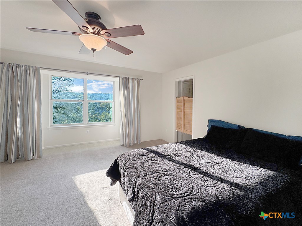 4575 Tanglewood Trail Spring Branch, TX 78070 - Photo 22 of 48 a bedroom with a large bed and a large window