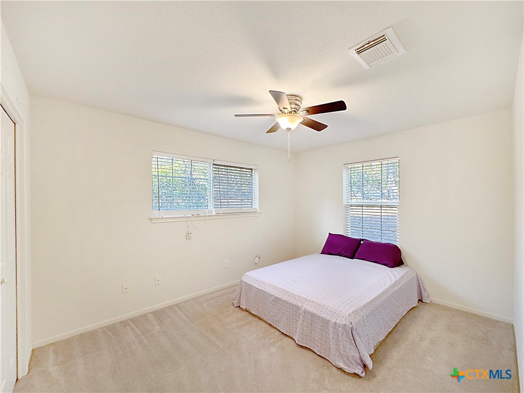 4575 Tanglewood Trail Spring Branch, TX 78070 - Photo 28 of 48 a bedroom with a large bed and a chandelier