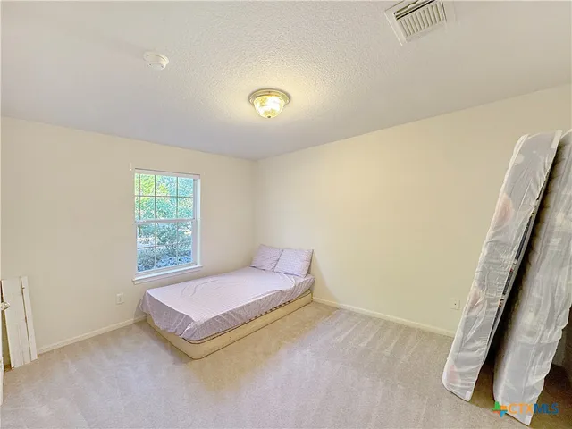 an empty room with a cabinet and mirrors