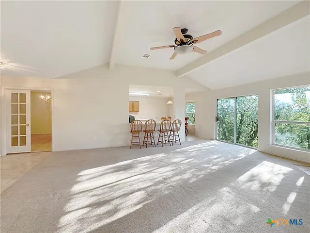 a view of a livingroom with a ceiling fan and windows